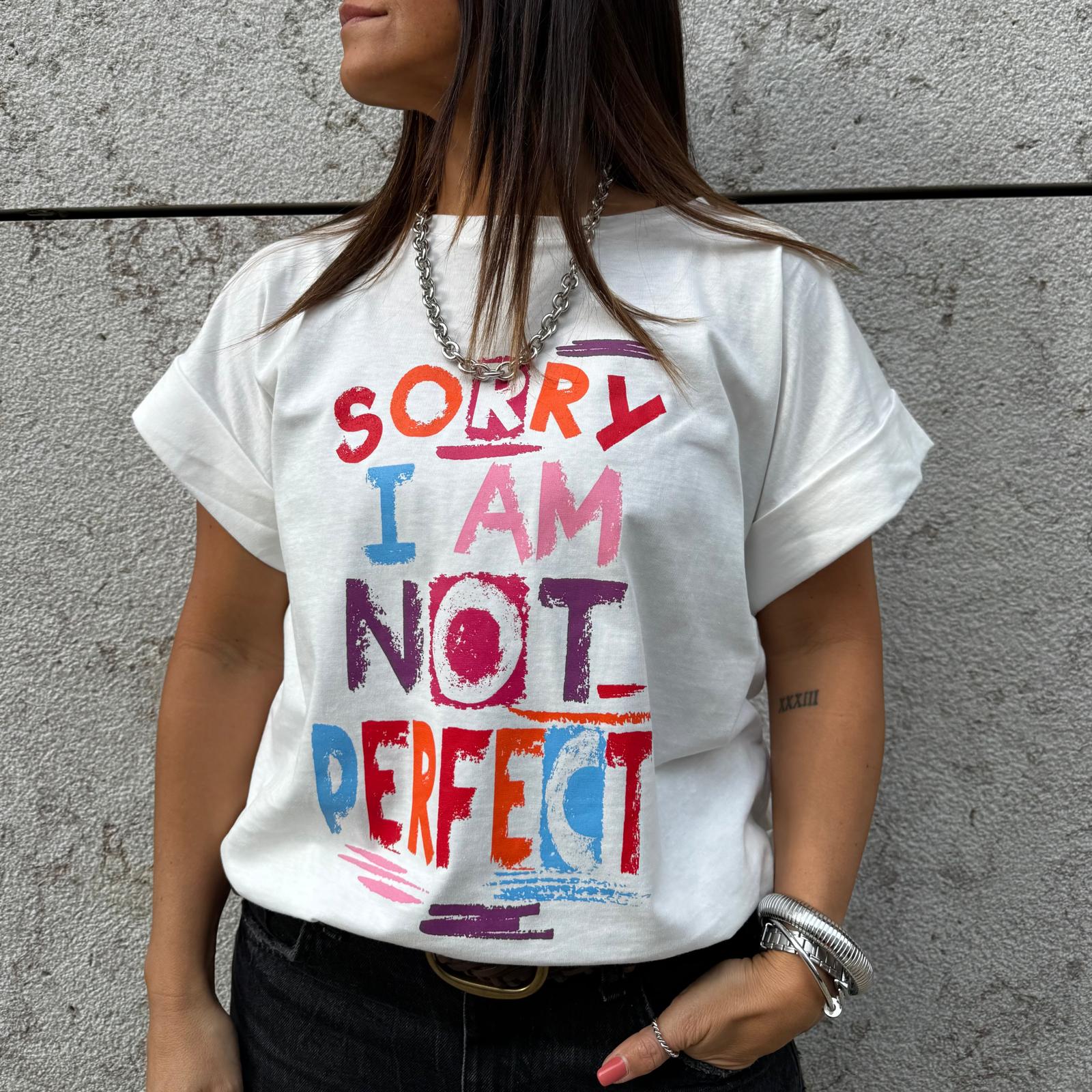 Mulher com t-shirt branca estampada com texto colorido contra parede cinza