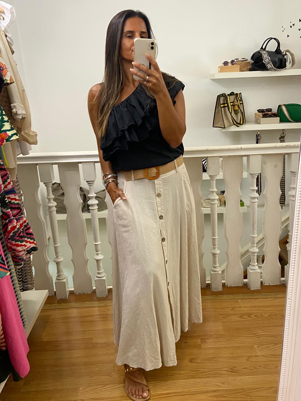 Mulher a tirar selfie em espelho com saia comprida bege e top preto com folhos