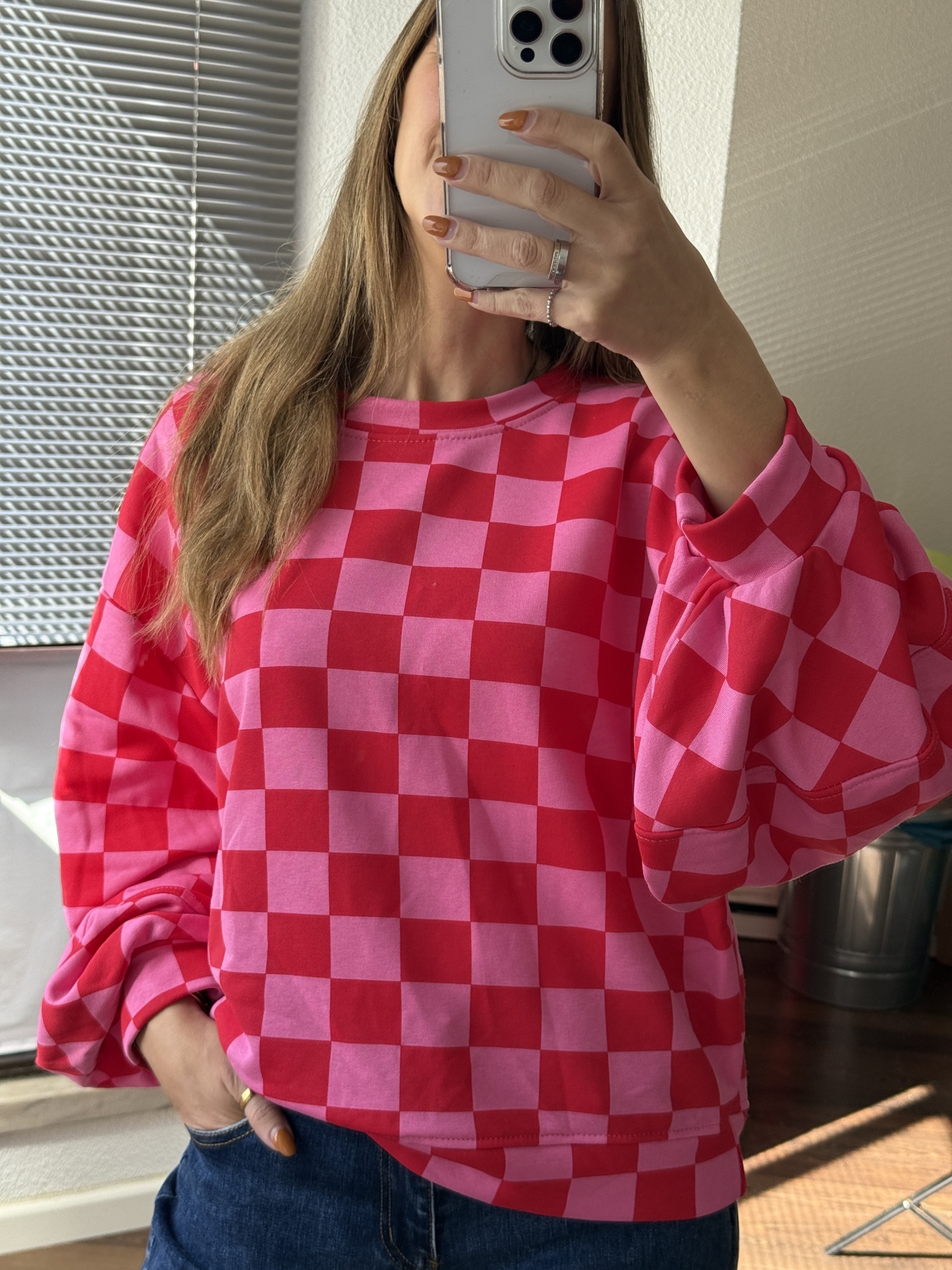 Sweatshirt xadrez rosa e vermelho, mangas compridas, gola redonda.