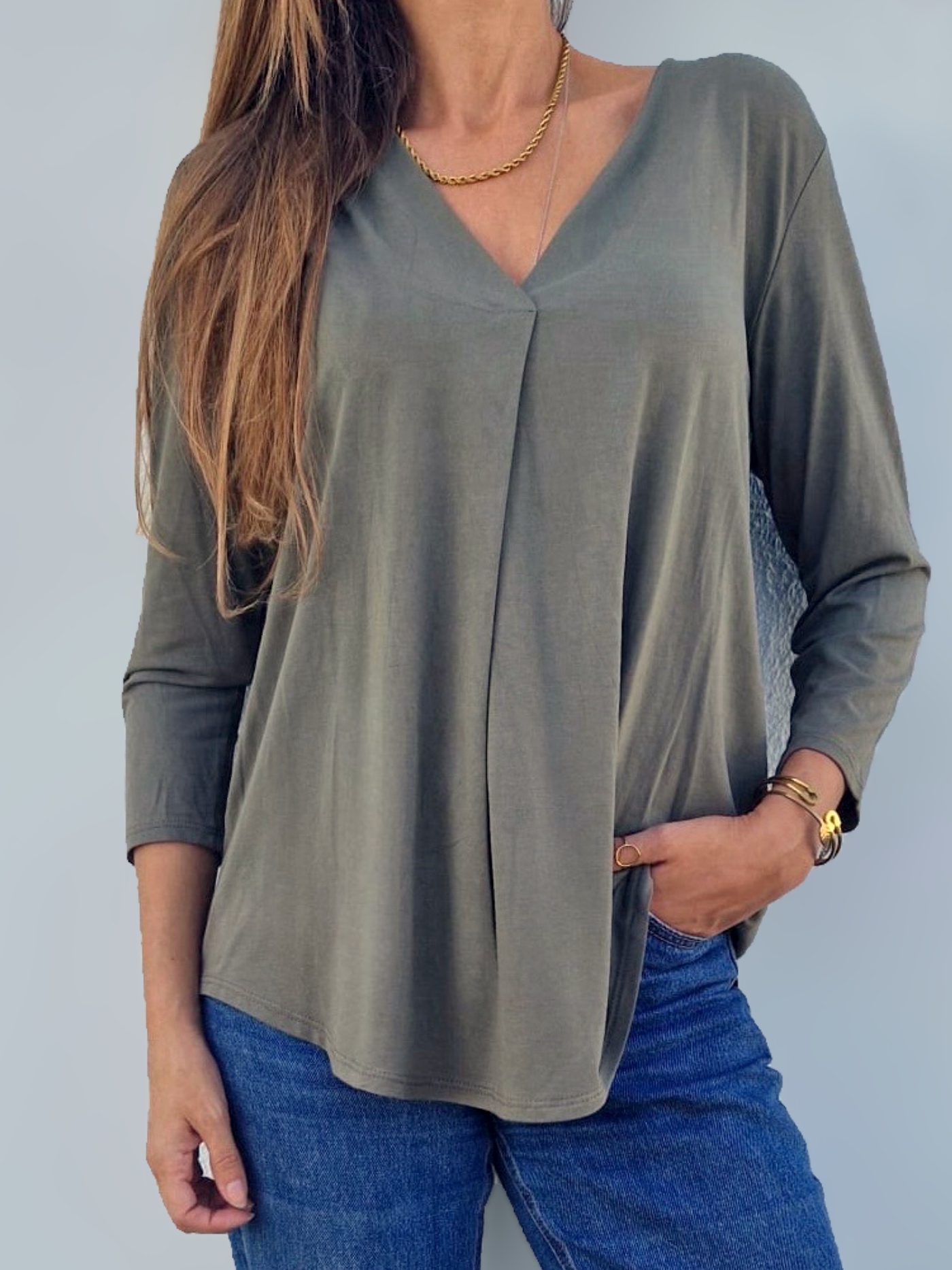 Blusa feminina verde-oliva de manga comprida e decote em V com jeans azul