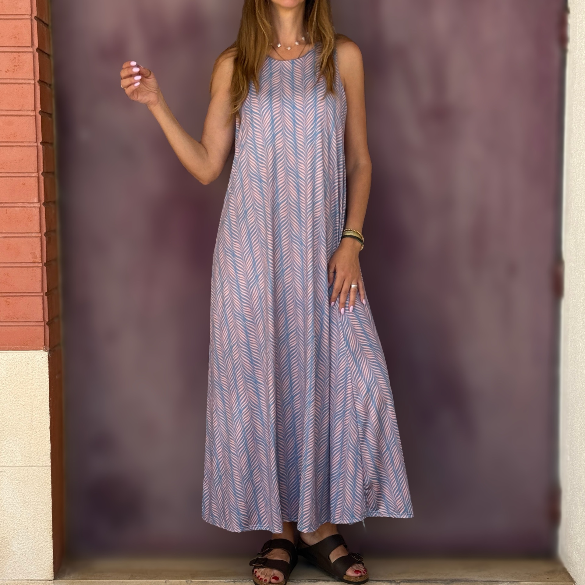 Vestido midi padrão geométrico azul e rosa, mulher com sandálias pretas e unhas rosa claro.