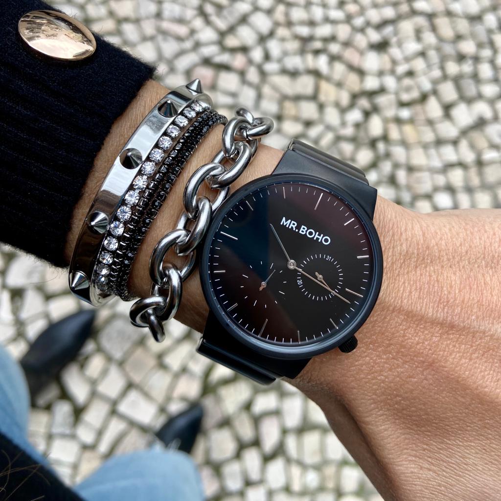 Relógio MR. BOHO preto com pulseiras prateadas e fundo de calçada