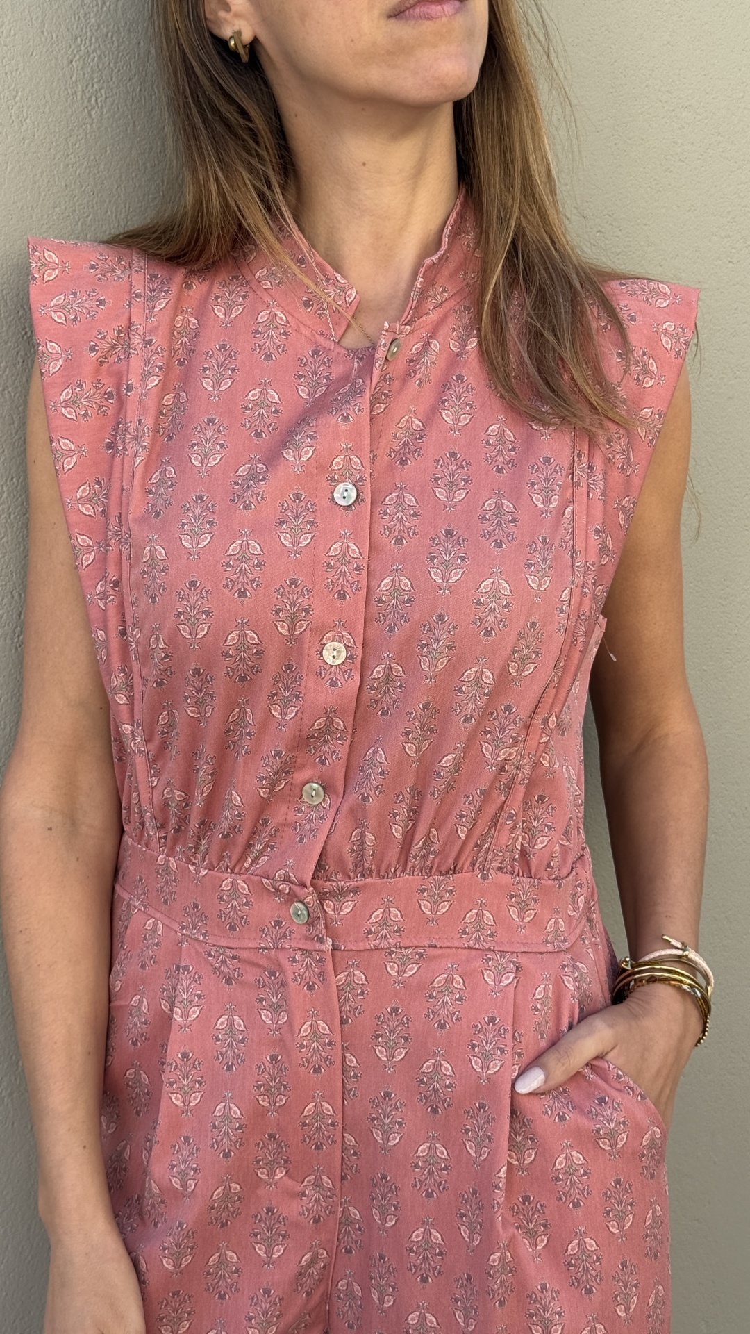 Macacão rosa com padrão floral e botões frontais