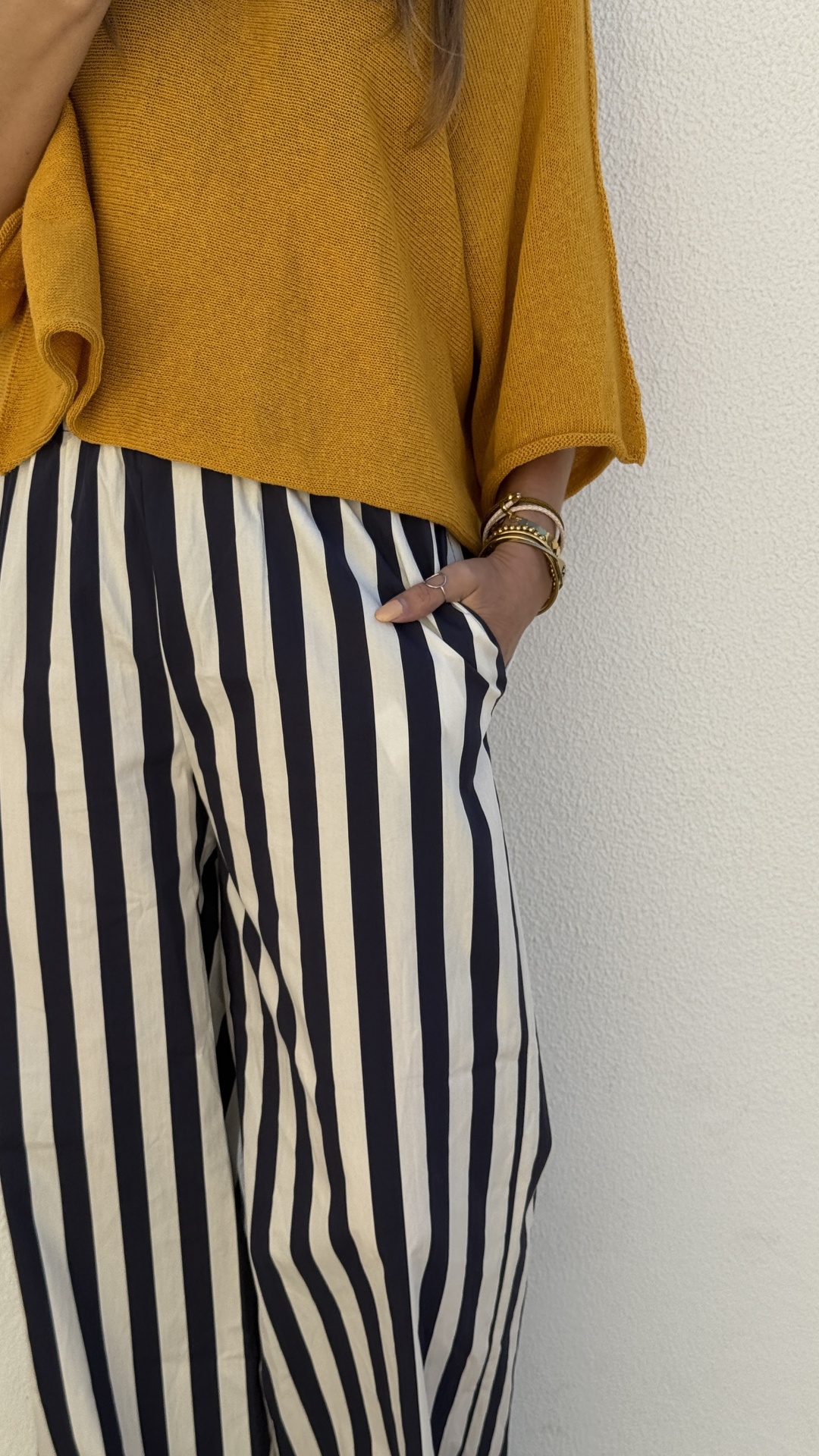 Calças riscas verticais azul e branco e camisa de malha amarelo mostarda