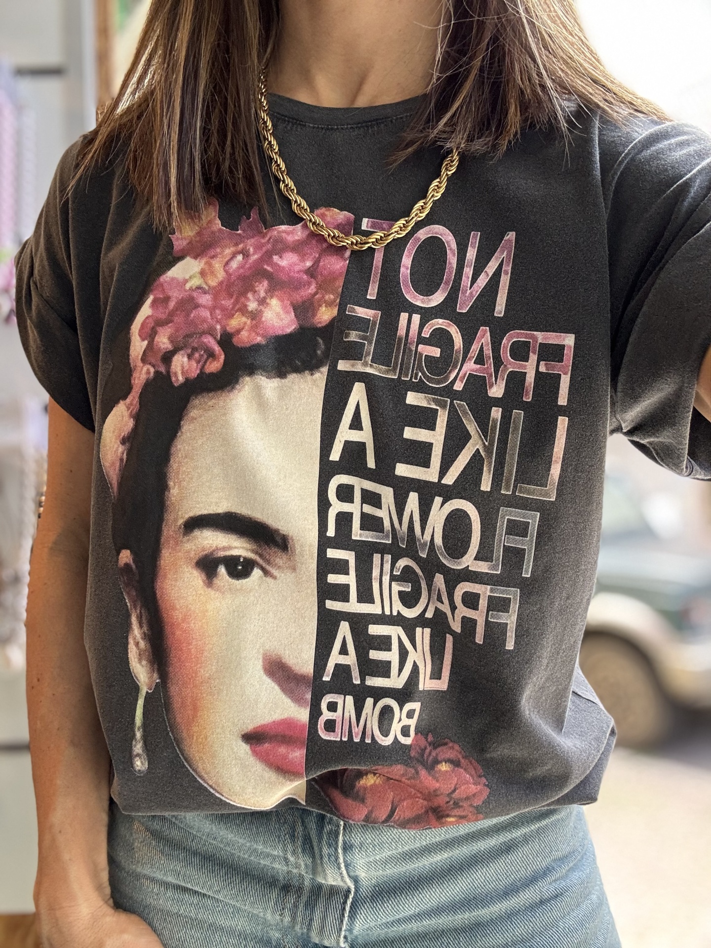 T-shirt preta com estampa colorida da metade do rosto de uma mulher e texto em inglês