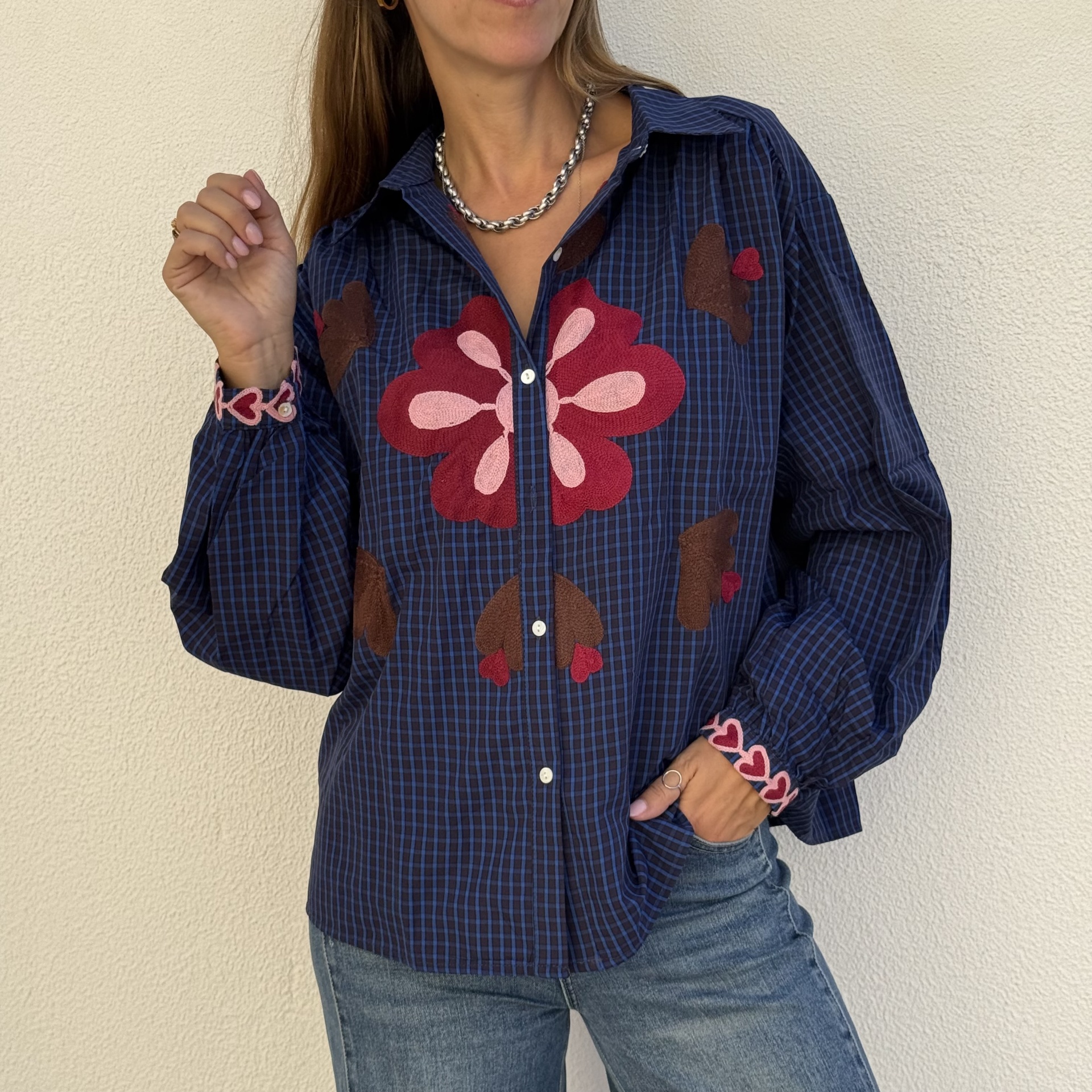 Camisa azul com aplicações florais e padrão xadrez