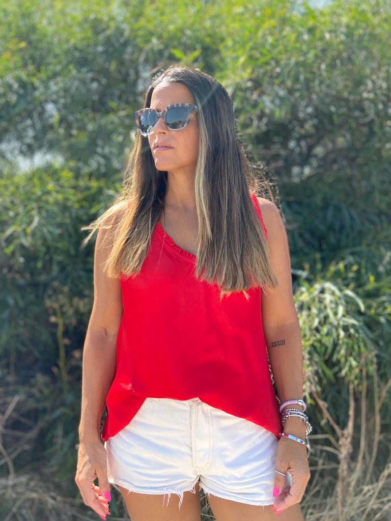 Mulher com top vermelho e calções brancos ao ar livre