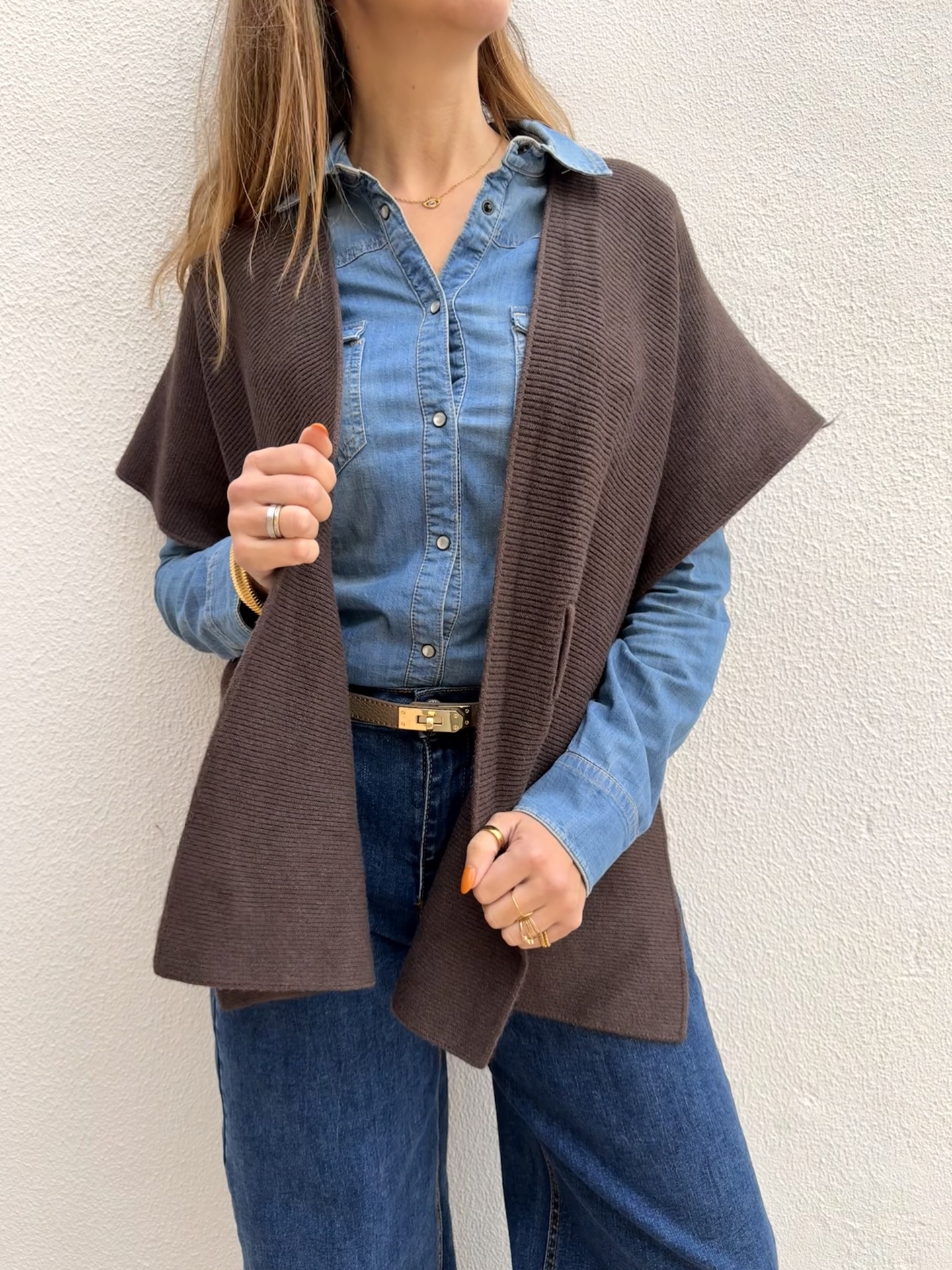 Xale castanho de malha canelada sobre camisa jeans azul claro e calças de ganga