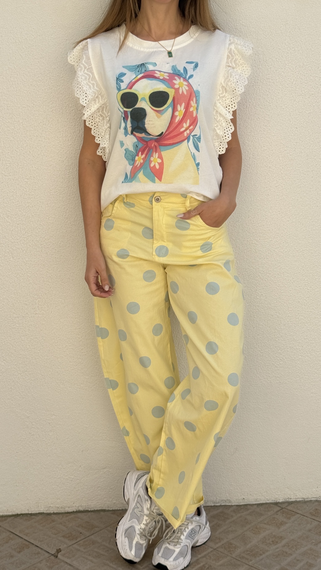 T-shirt branca com estampa de cão e calças amarelas com bolas cinzentas