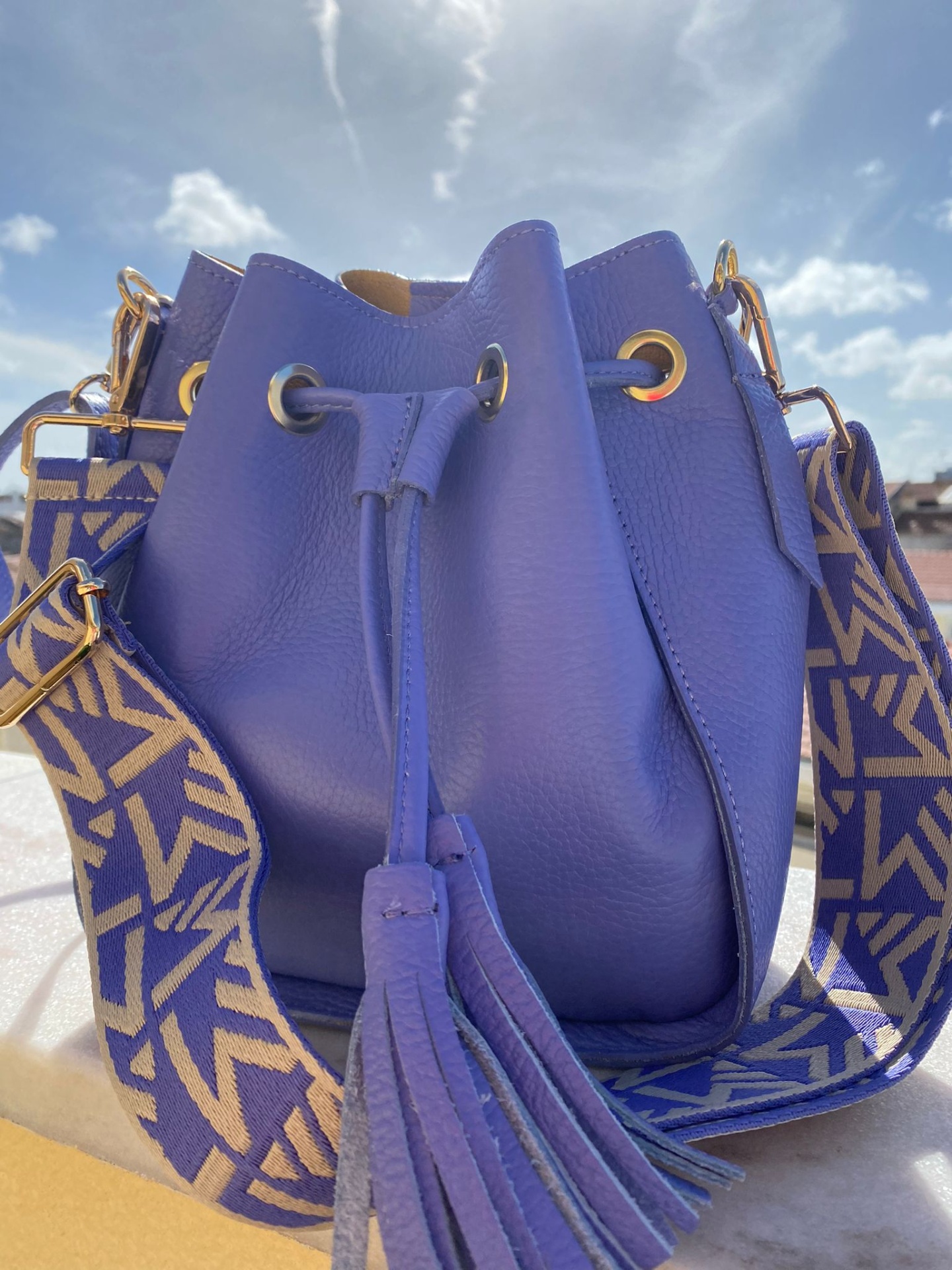 Mala saco azul em pele com alça larga padrão geométrico