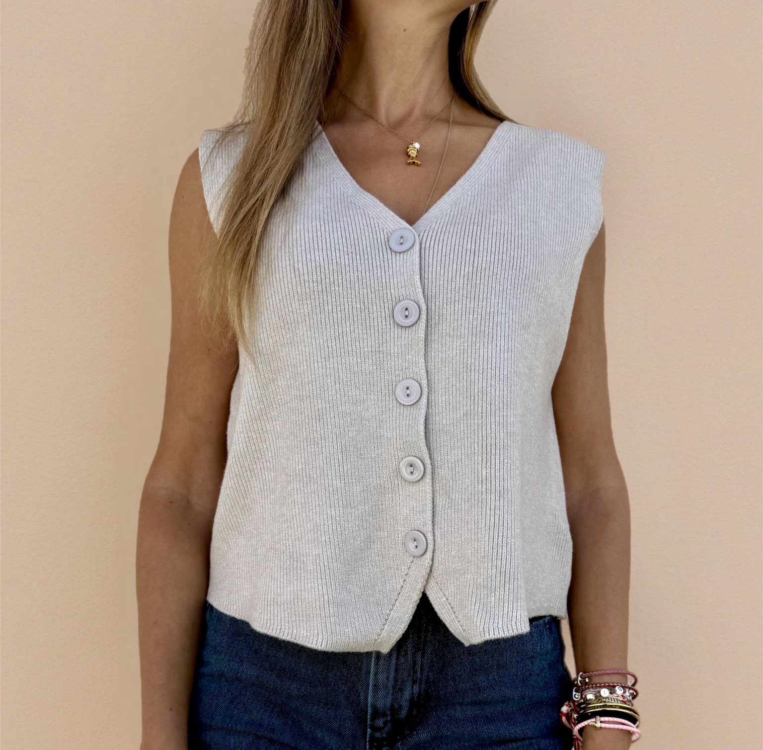 Colete de malha bege com botões e padrão canelado