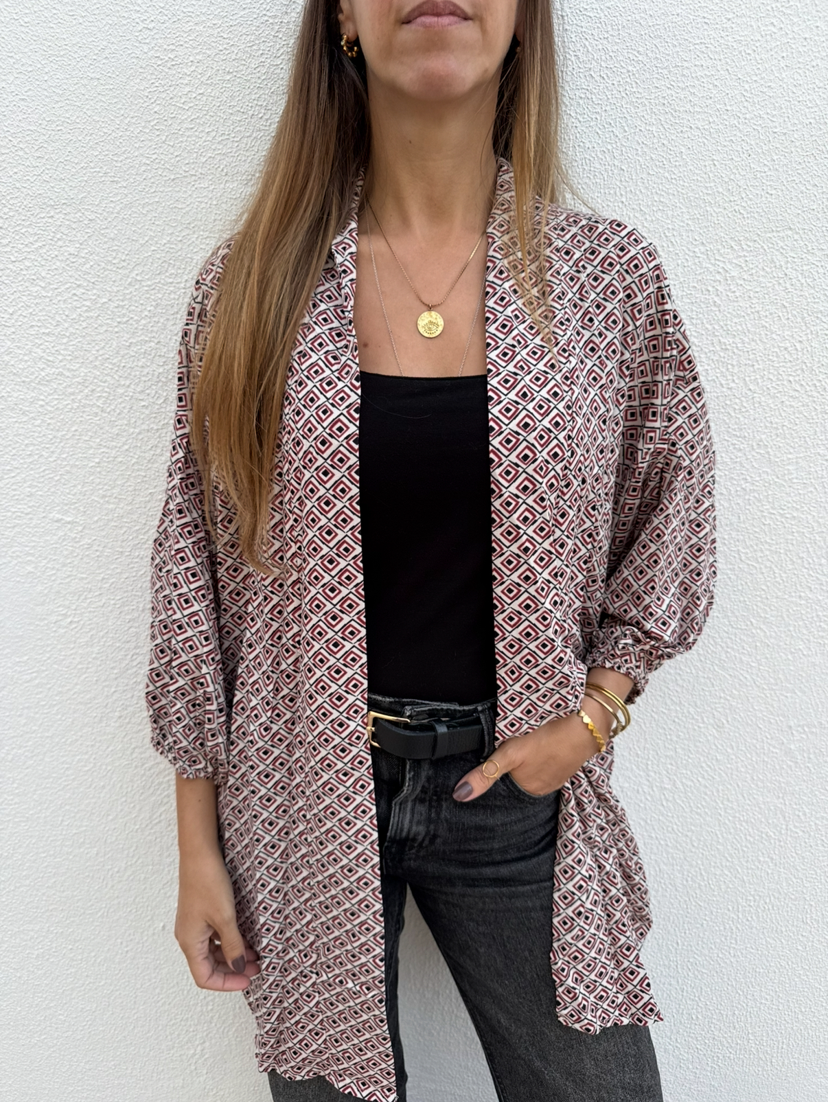 Casaco com padrão geométrico multicolor sobre fundo branco