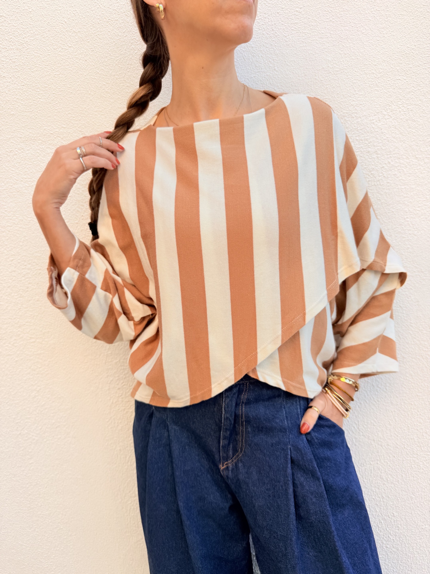 Blusa com riscas verticais em bege e castanho claro e calças de ganga azuis