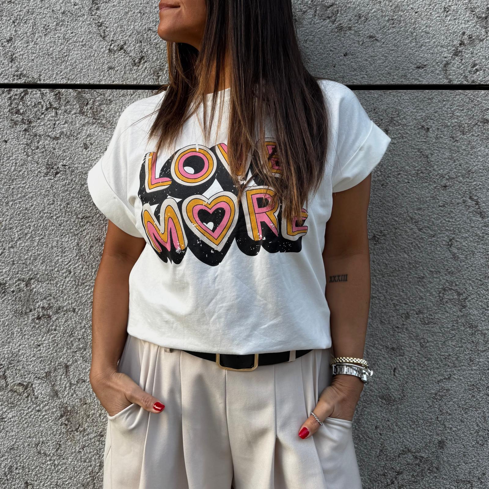 T-shirt branca com texto colorido 'LOVE MORE'