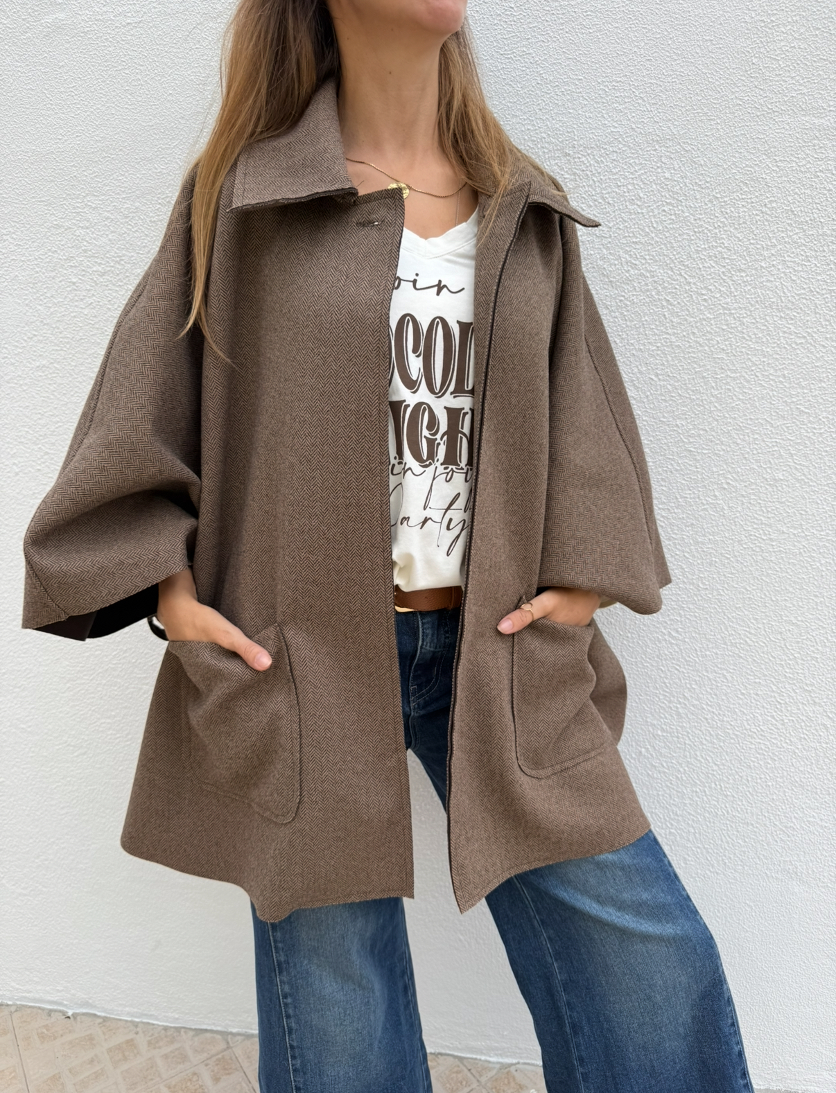 Casaco castanho com padrão espinha de peixe e bolsos frontais