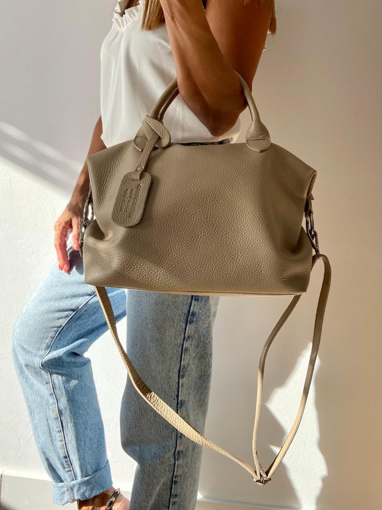 Mala de mão bege em pele com alças curtas e longa, usada ao ombro