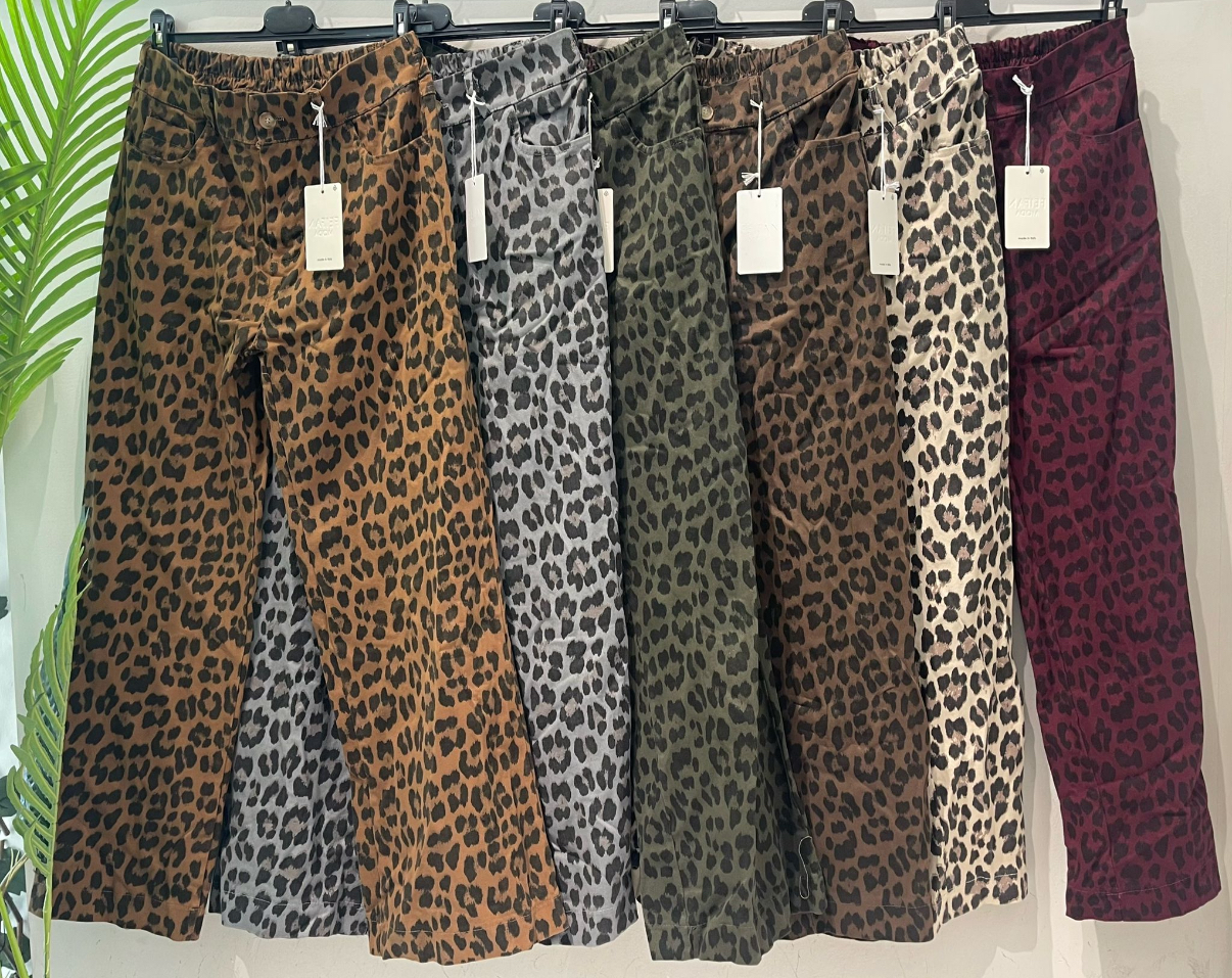 Seis calças com padrão de leopardo em várias cores penduradas numa fila