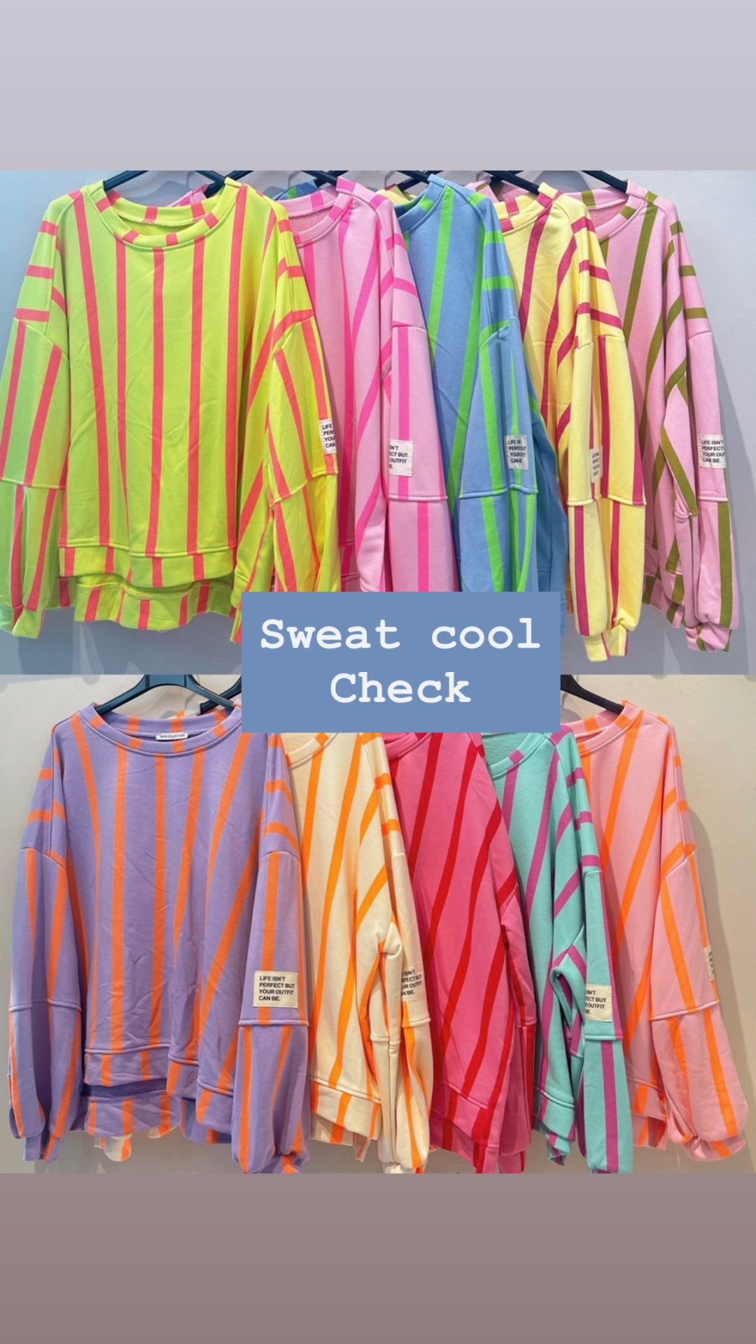 Conjunto de sweats coloridos às riscas pendurados em cabides.