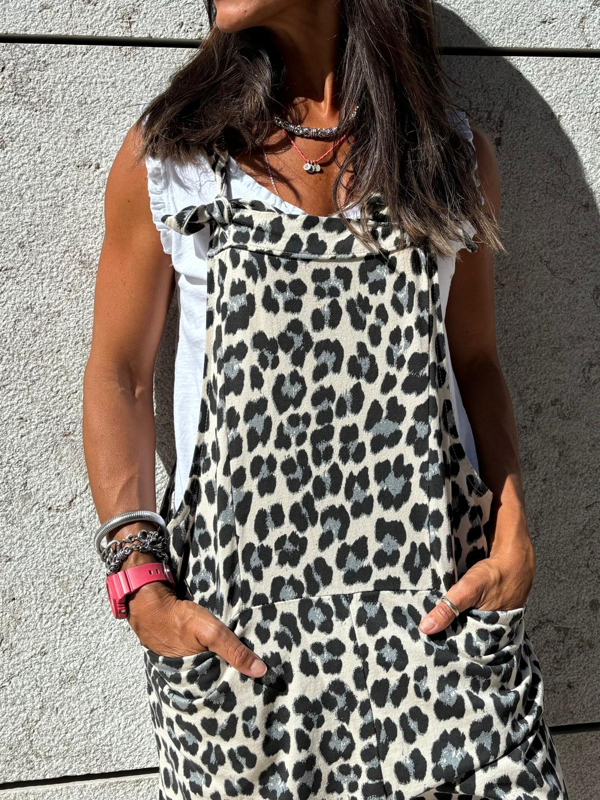 Macacão com padrão animal print bege, cinza e preto, com bolsos, usado sobre t-shirt branca