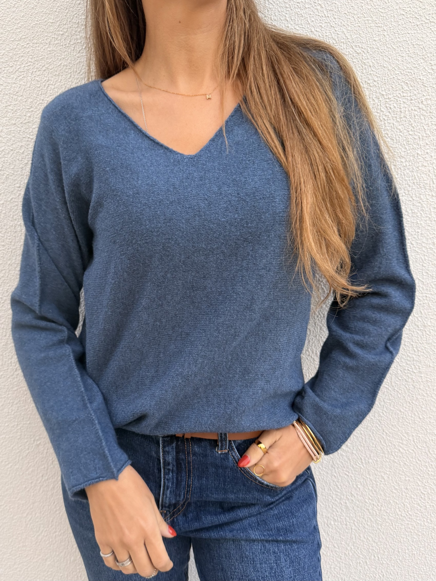 Camisola azul de malha com decote em V e calças de ganga azul escuro