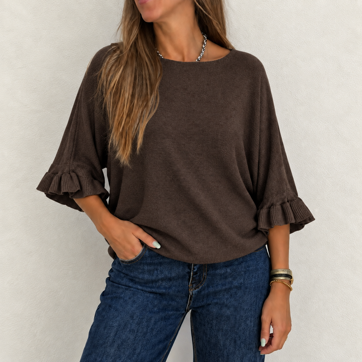 Camisola castanha de manga 3/4 com folhos nas extremidades e calças de ganga azuis