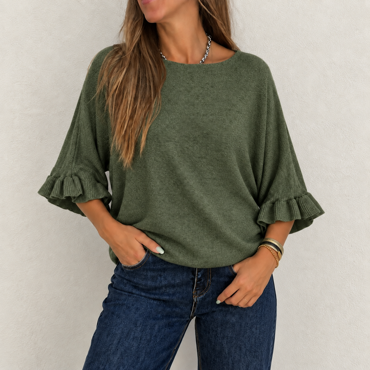 Camisola verde com folhos e calças de ganga azuis