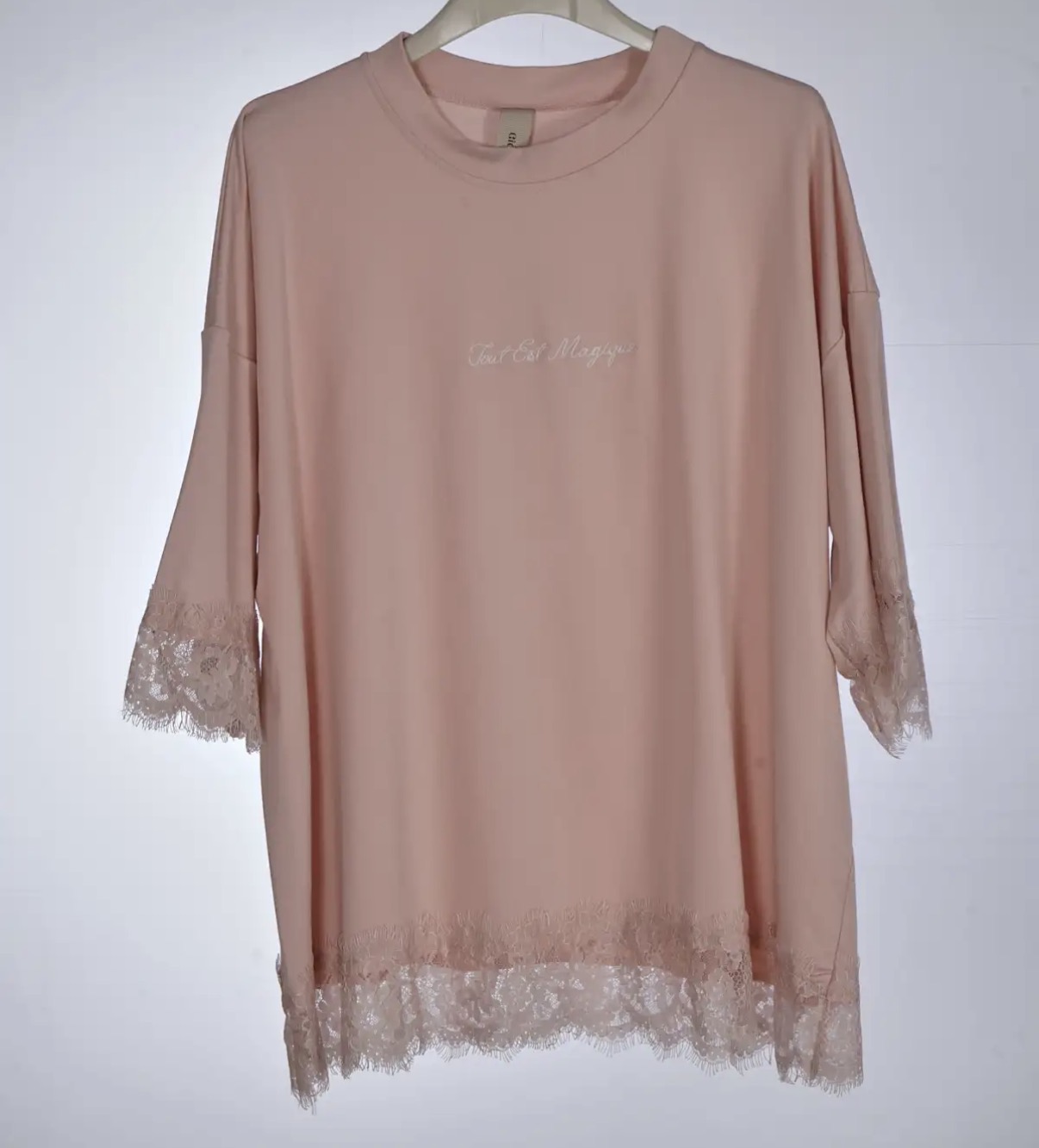 Túnica rosa clara com renda nas mangas e barra, texto bordado ao centro.