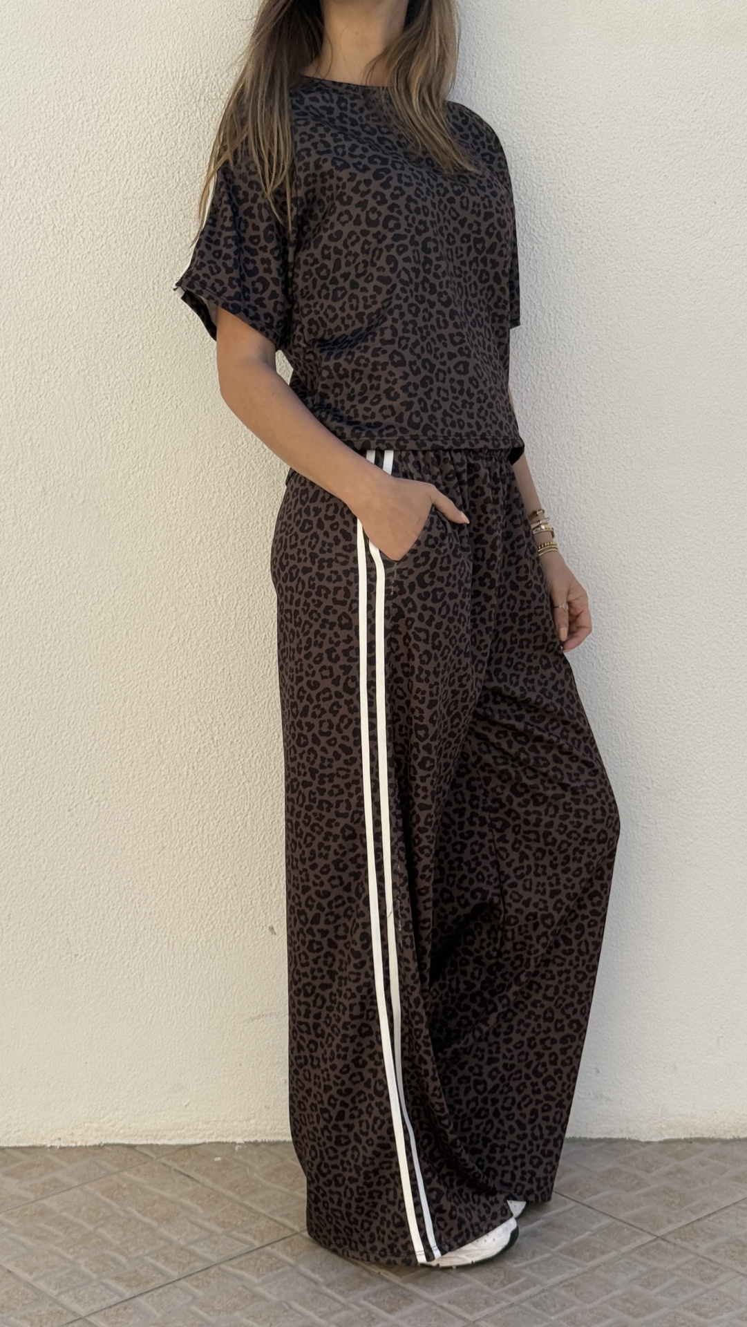 Conjunto de roupa feminina com padrão de leopardo e riscas brancas nas calças