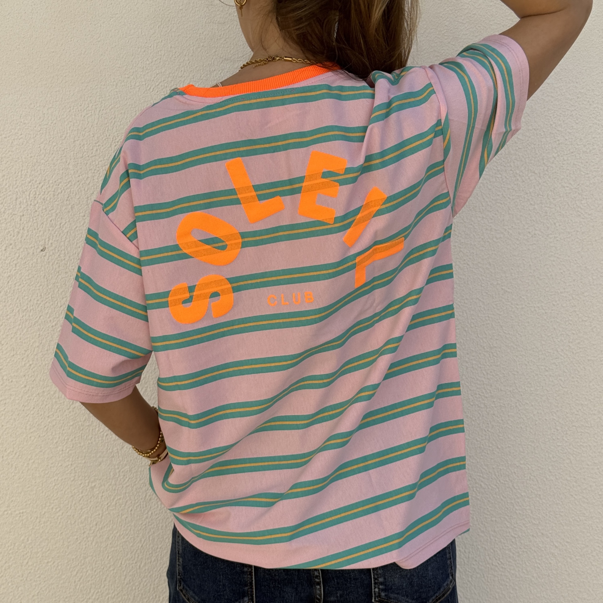 T-shirt rosa às riscas com texto laranja nas costas