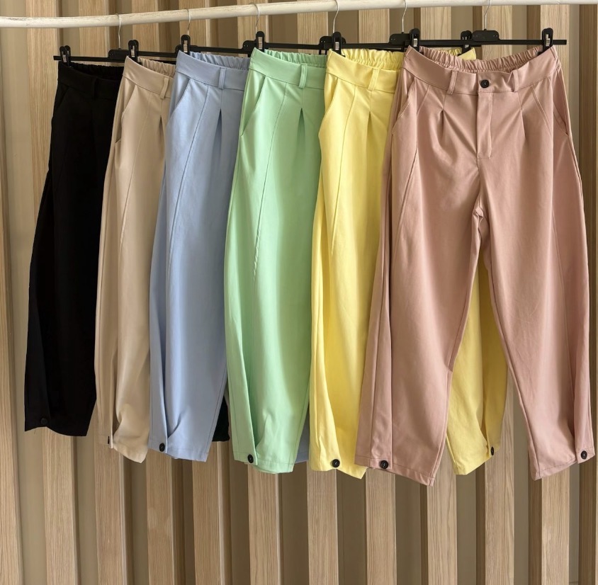 Seis calças femininas de várias cores penduradas em cabides