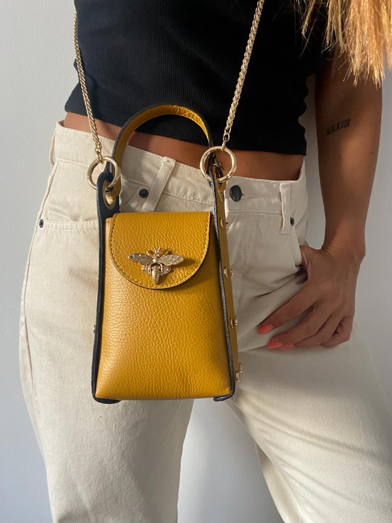 Bolsa pequena de couro amarelo com detalhe em metal dourado e alça de corrente dourada