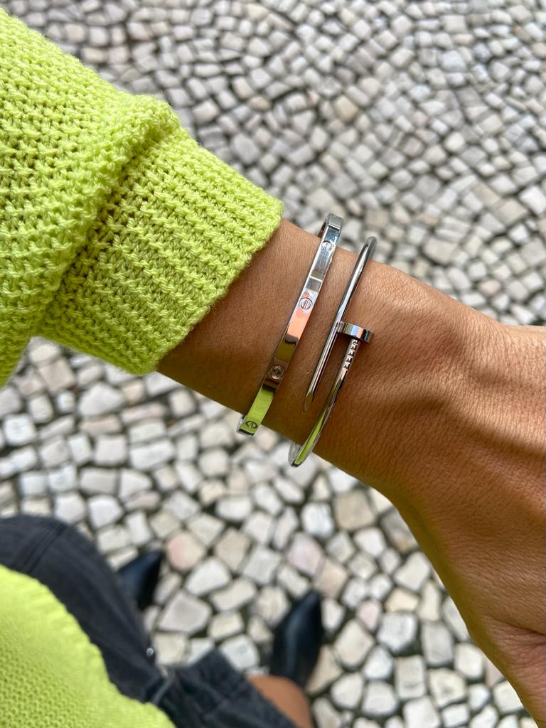 Pulso com pulseiras prateadas e camisola verde fluorescente