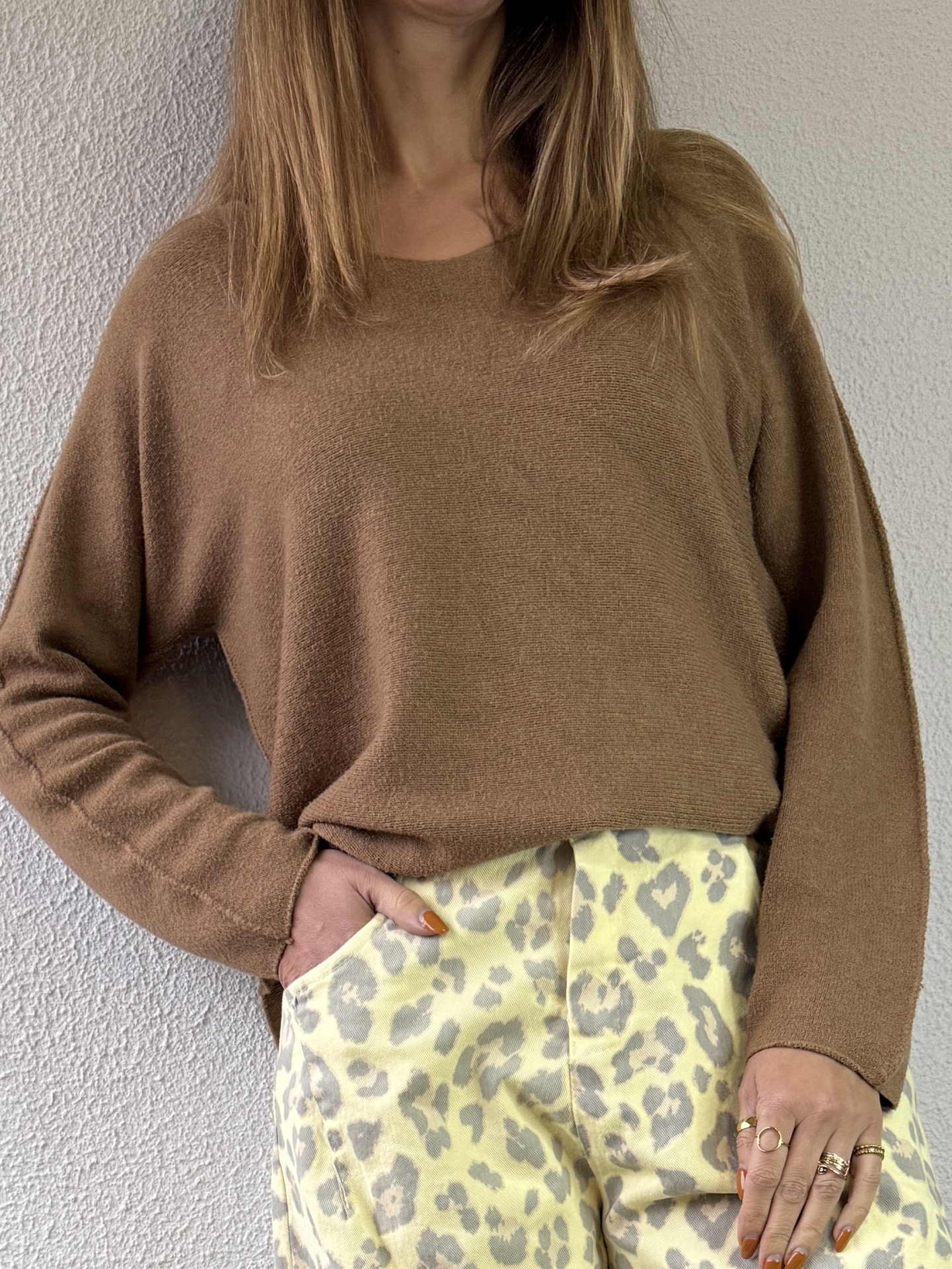 Pessoa a usar pulôver castanho e calças com padrão leopardo