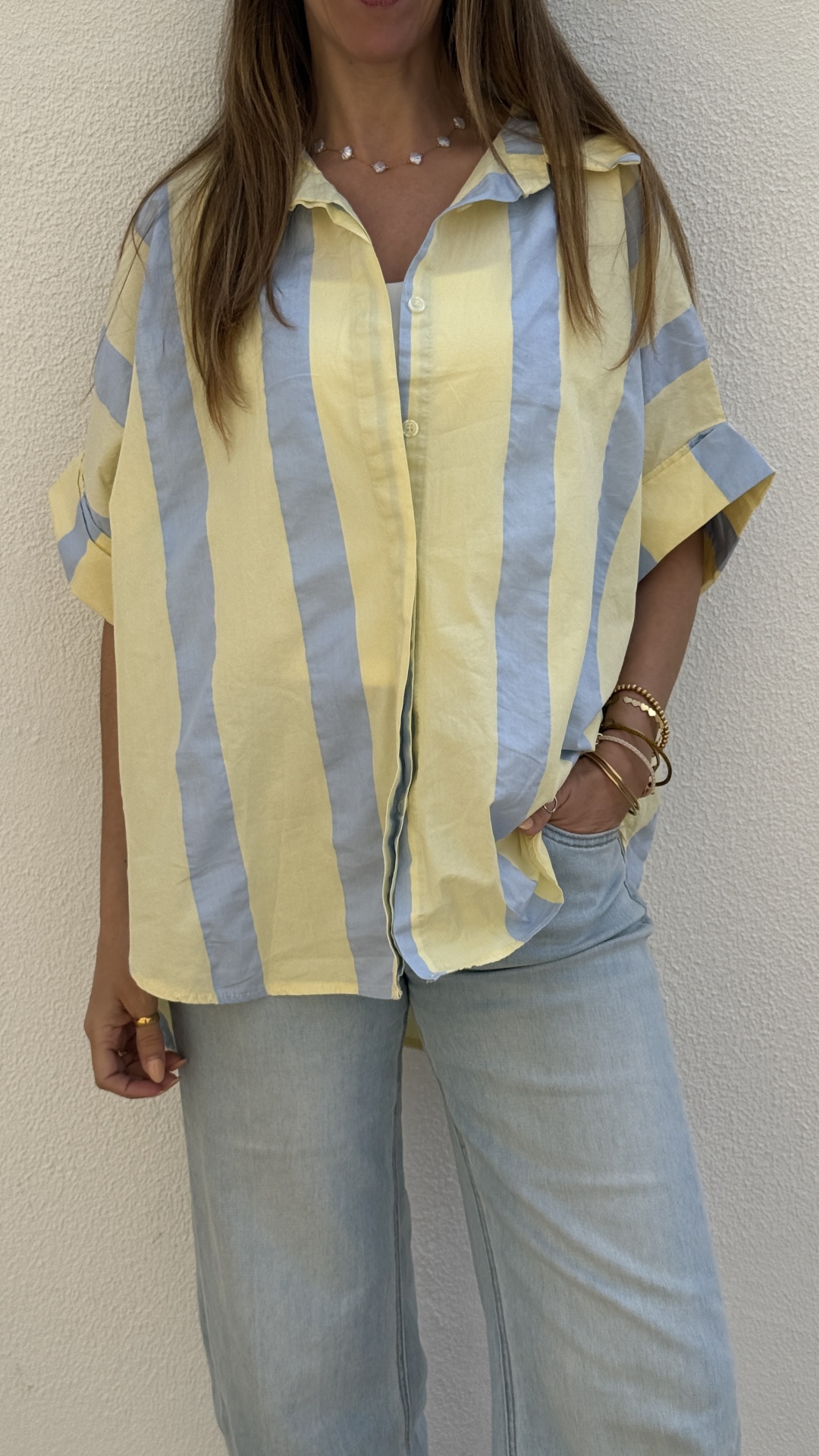 Camisa de riscas amarelas e azuis com botões e calças de ganga claras