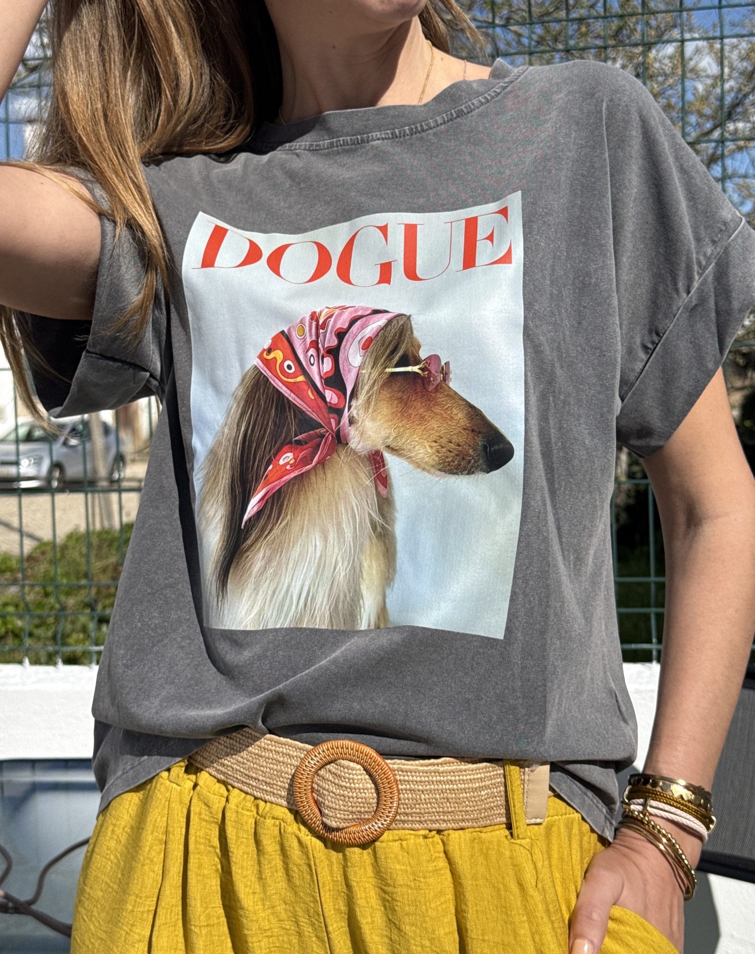 T-shirt cinzenta com estampa de cão com lenço rosa e óculos, texto DOGUE vermelho.