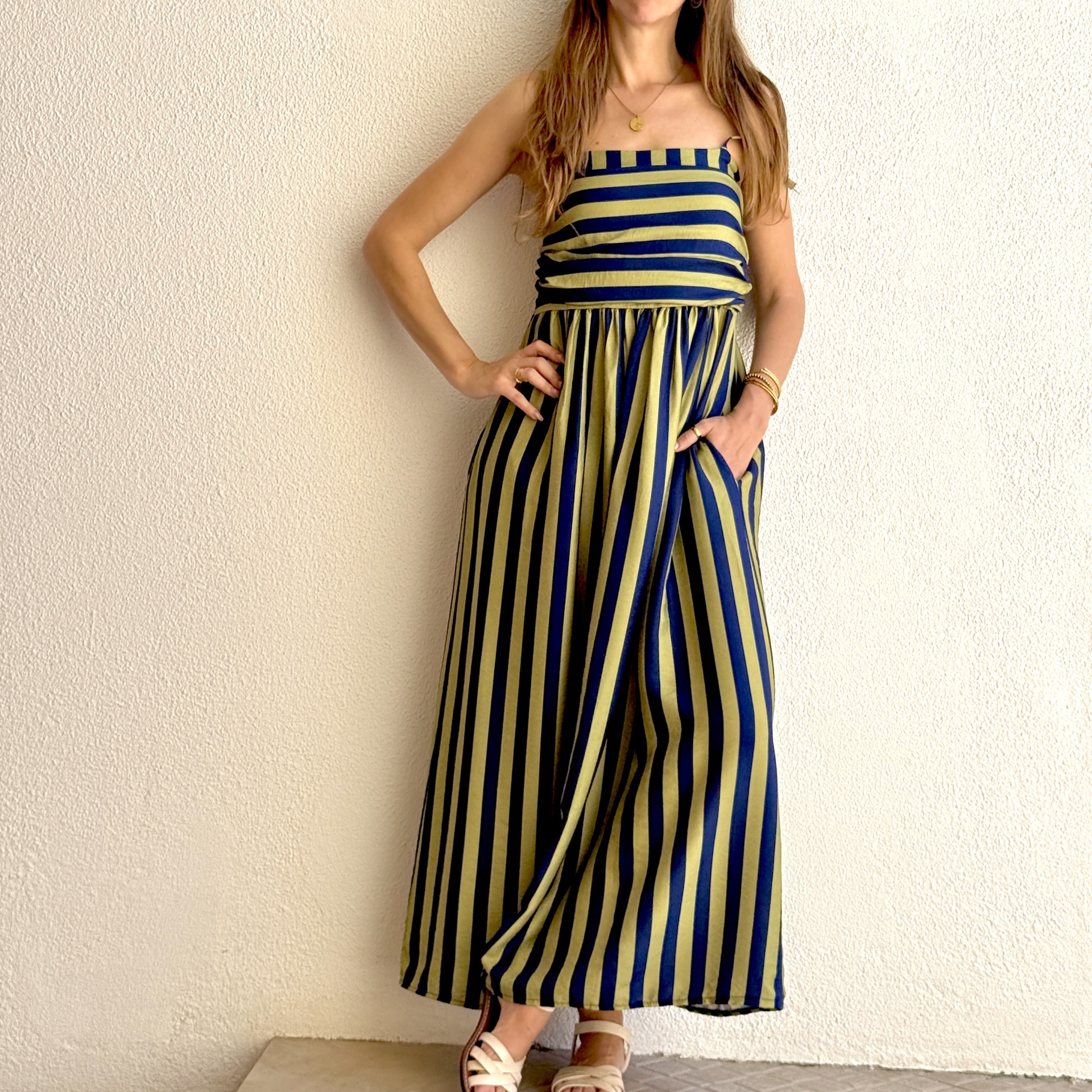 Vestido comprido de riscas azuis e verde-oliva com sandálias brancas
