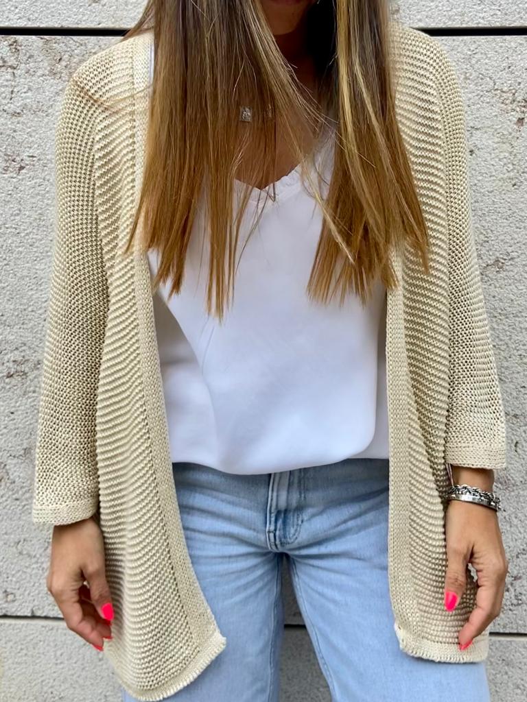 Cardigan bege estilo malha usado com blusa branca e calças de ganga azul claro