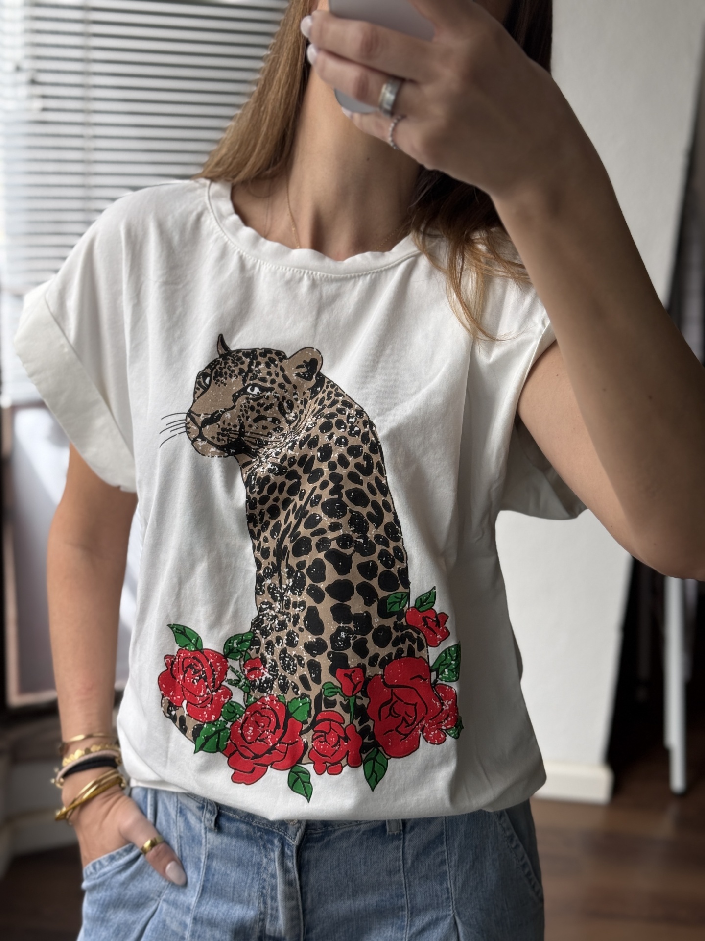 T-shirt branca com estampa de onça pintada e flores vermelhas