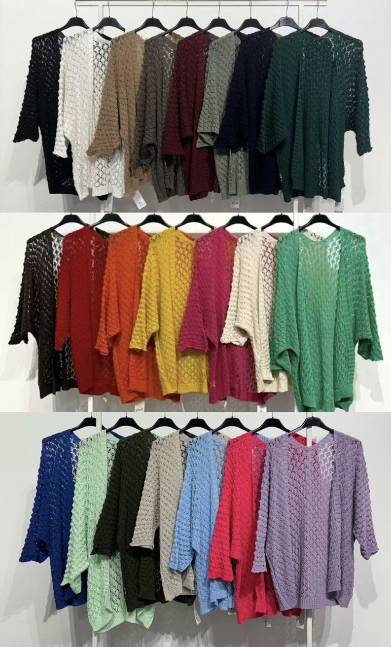 Blusas de malha coloridas com padrão de pontos abertos penduradas em cabides