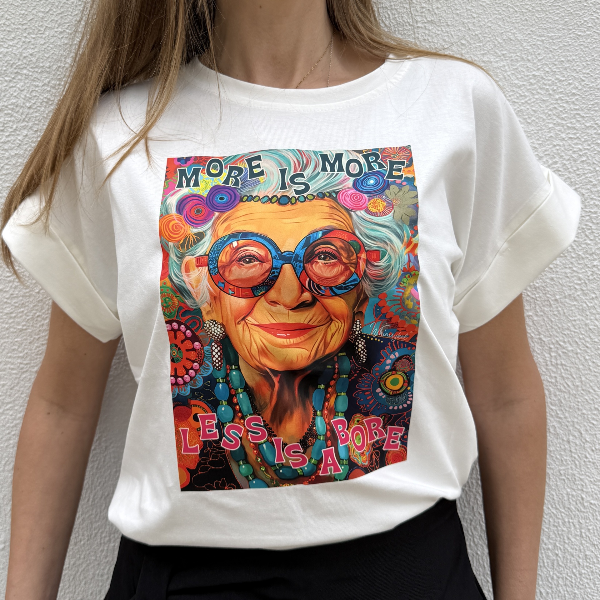 T-shirt branca com estampa colorida de senhora idosa e texto MORE IS MORE LESS IS A BORE