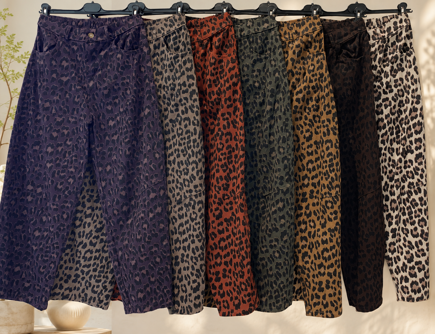 Calças com padrão animal print em diferentes cores penduradas em cabides
