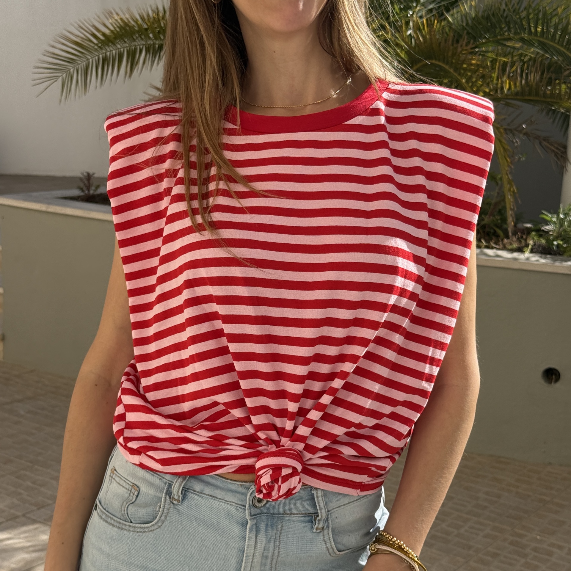 T-shirt de riscas vermelhas e brancas com nó frontal e calças de ganga claras