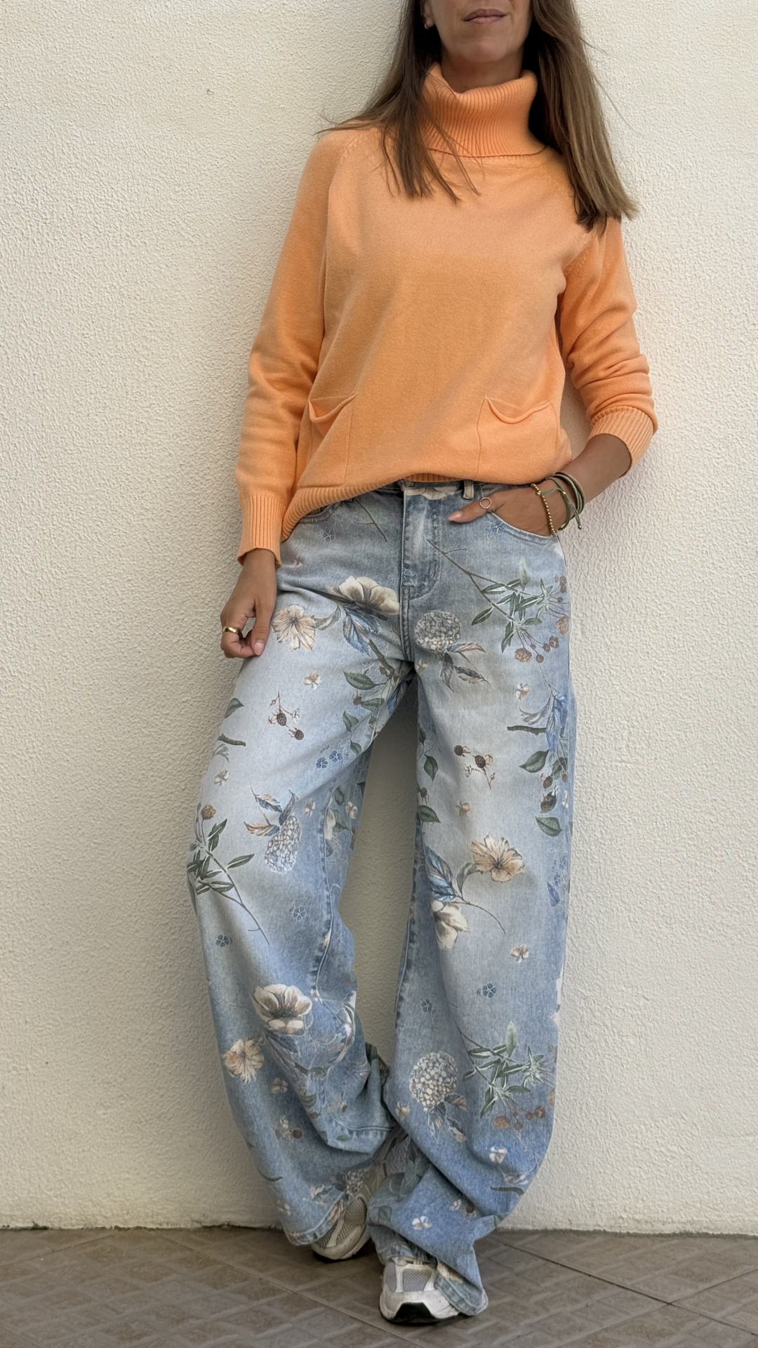 Pullover laranja de gola alta com calças de ganga azul claro e padrão floral