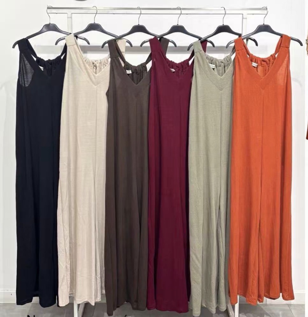 Seis vestidos compridos coloridos pendurados em cabides num varão