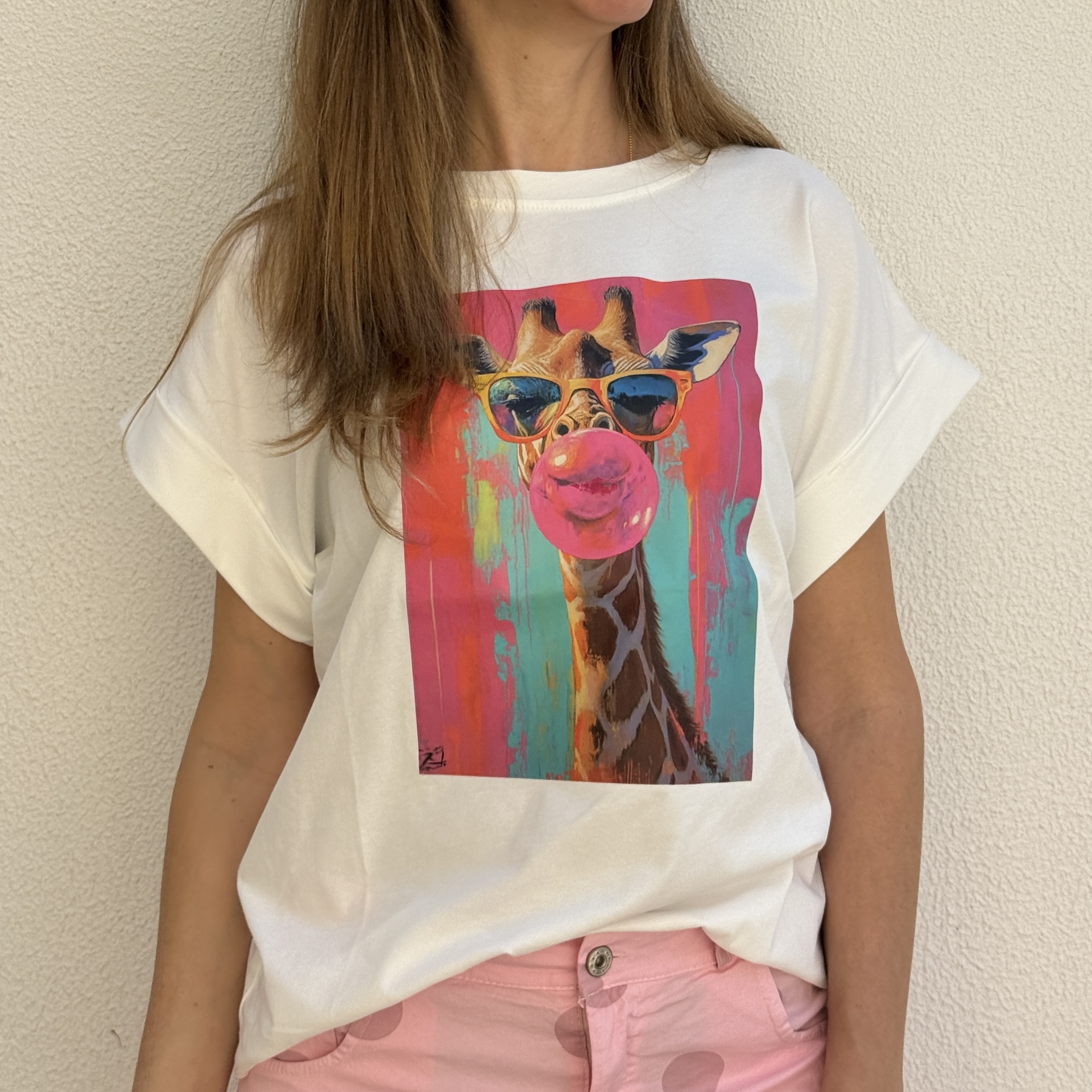 T-shirt branca com estampa de girafa com óculos de sol e bola de pastilha rosa.
