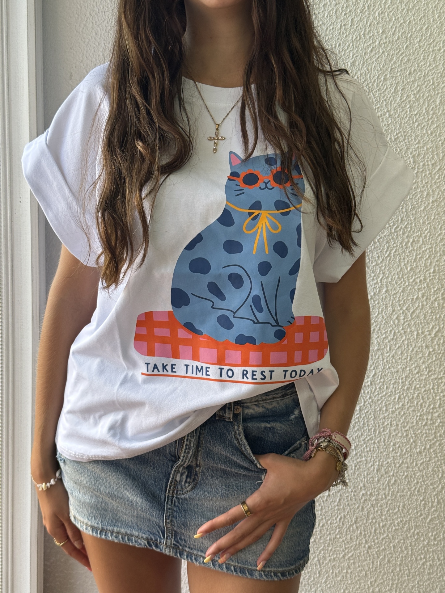 T-shirt branca com estampa de gato azul e texto em inglês.