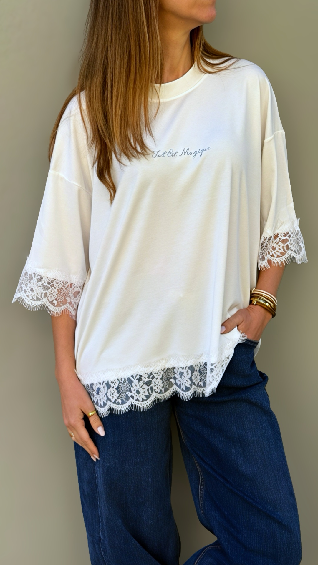 T-shirt branca com renda nas mangas e barra com calças de ganga azul escuro