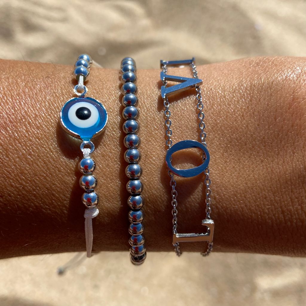 Três pulseiras prateadas numa mão com pele bronzeada