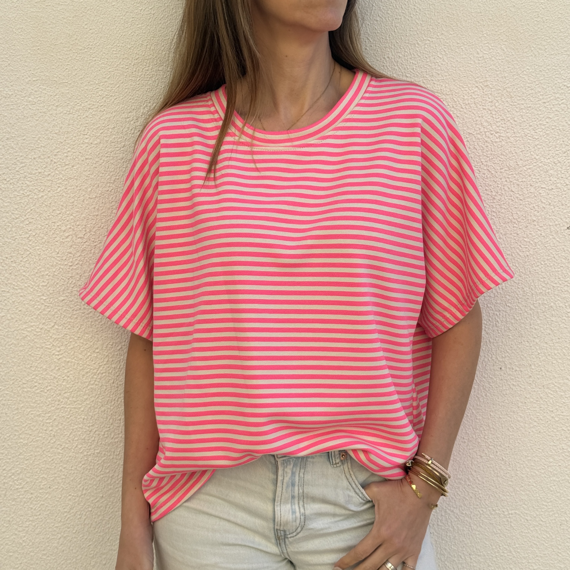 T-shirt feminina às riscas rosa e bege, com decote redondo e mangas curtas.