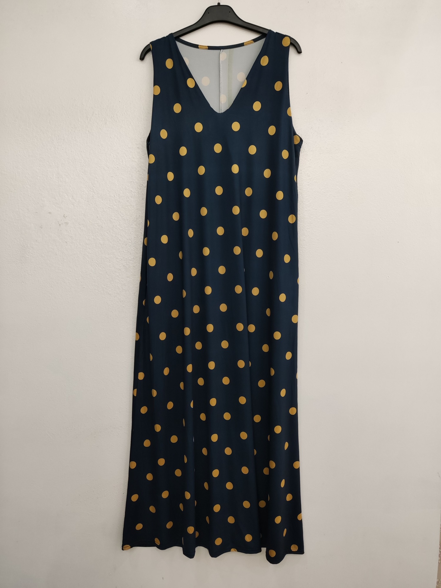 Vestido azul escuro com bolinhas amarelas pendurado